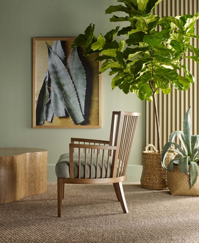 Wooden chair on natural fiber rug surrounded by plants