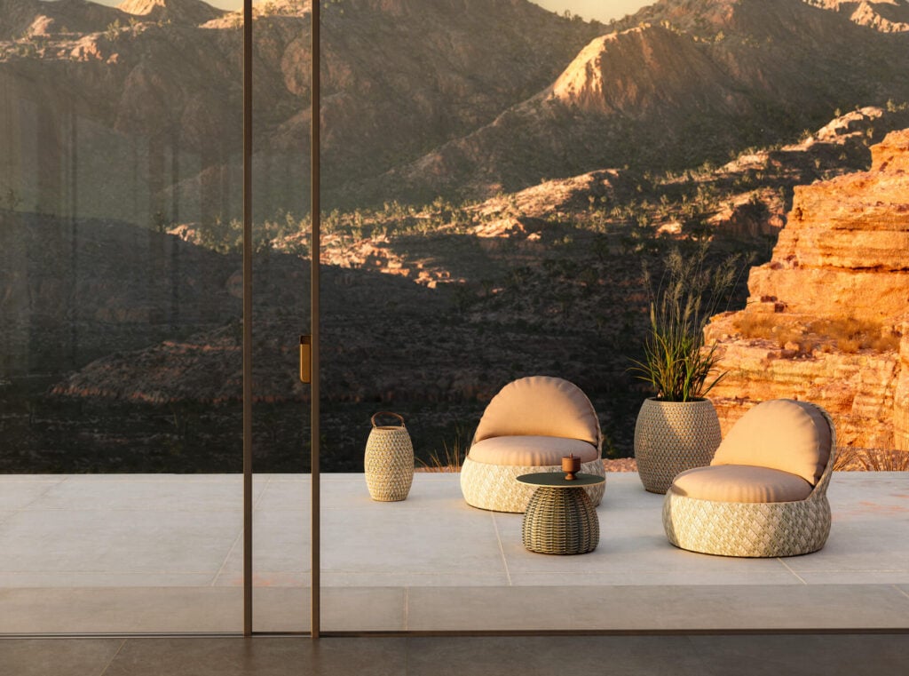 Two seats and a table on a patio in a desert landscape