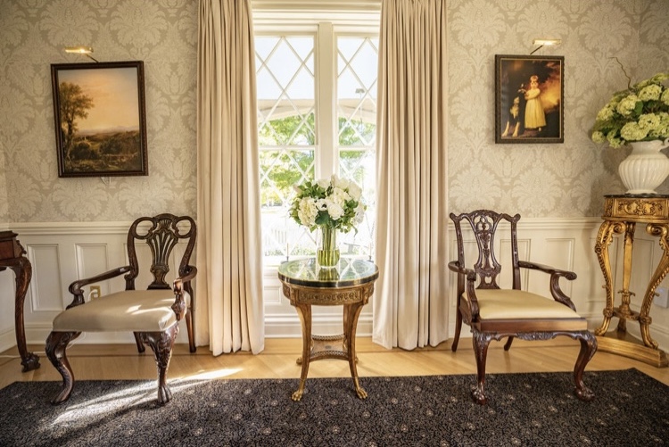 Two chairs and a table make a sitting area by a window