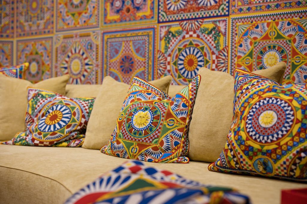 Brightly patterned pillows on a yellow couch