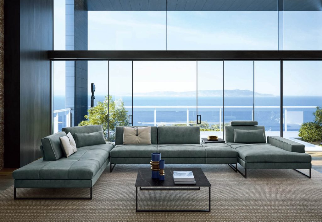 Modern blue leather sectional with a glass wall and sea behind it