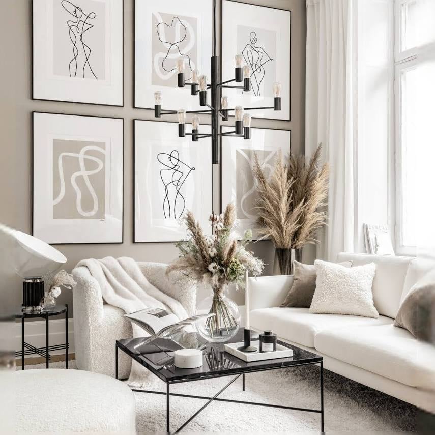 White curved chairs and sofa with a black coffee table and warm neutral walls
