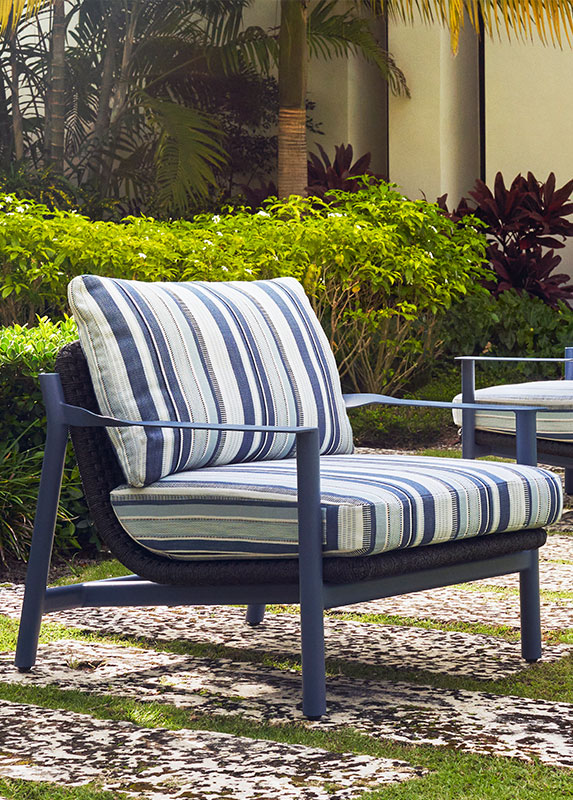 An Brown Jordan lounge chair with a blue frame and blue striped cushions