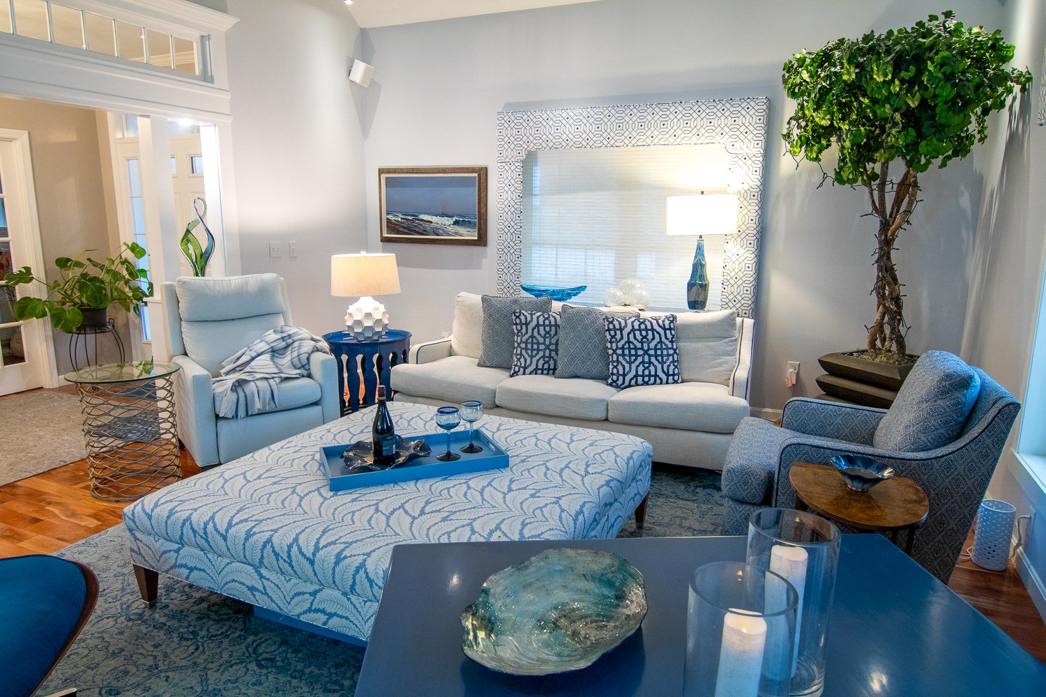 Another view of a living room with white furnishings and shades of blue accents. 