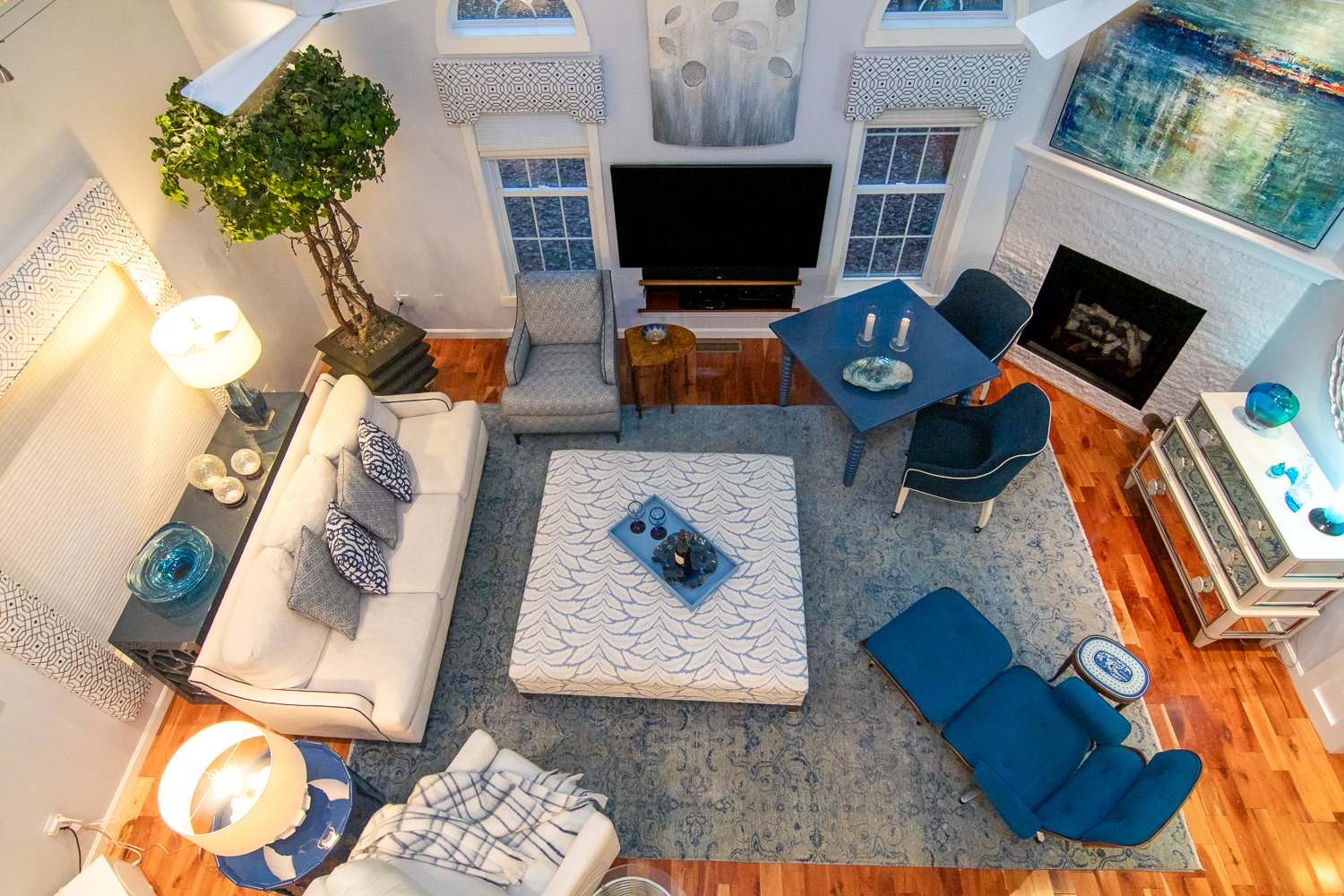 Looking down at an elegant living room with a white couch and blue Eames chair