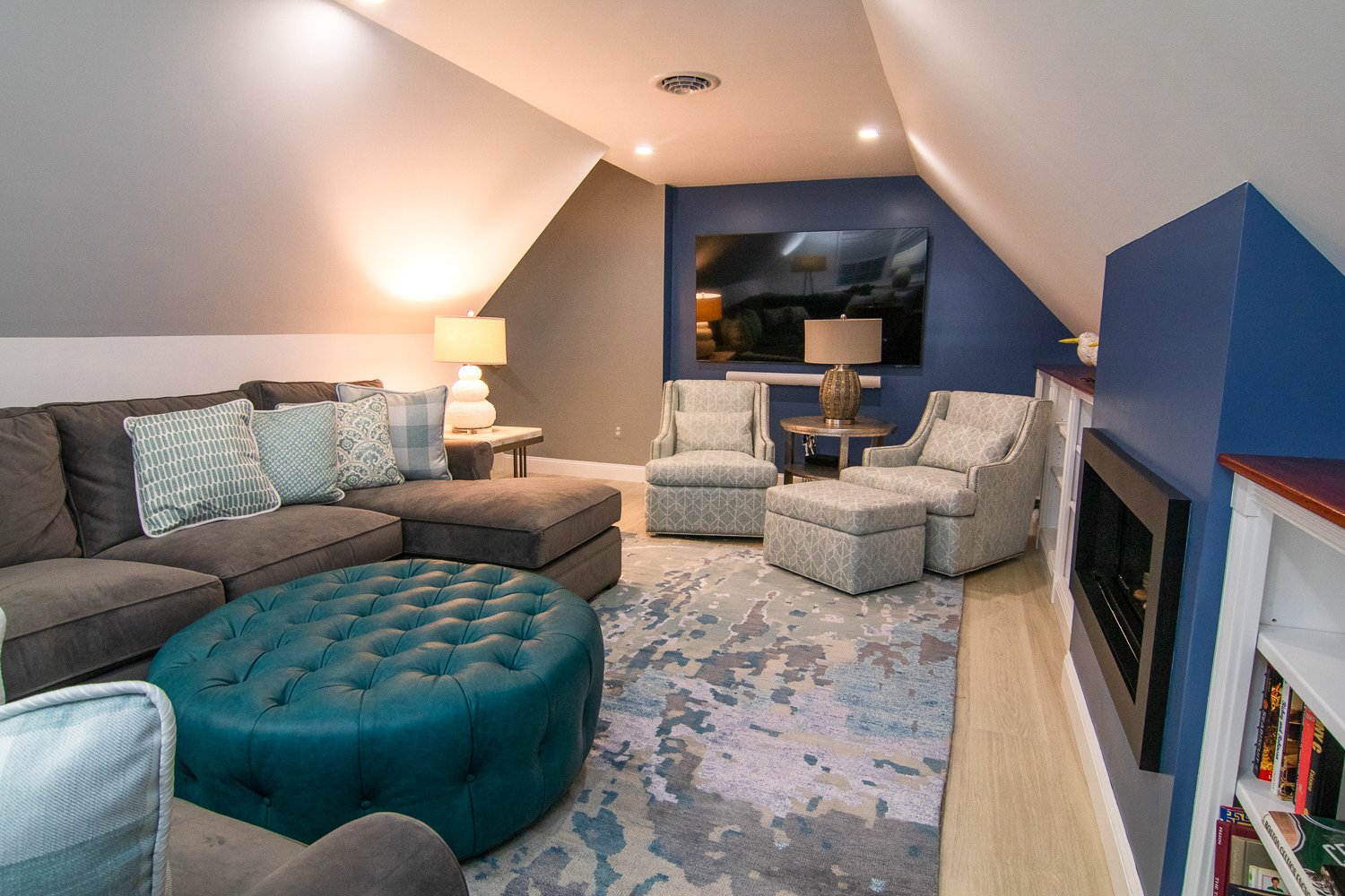 An attic den space with slanted ceiling and blue accent wall