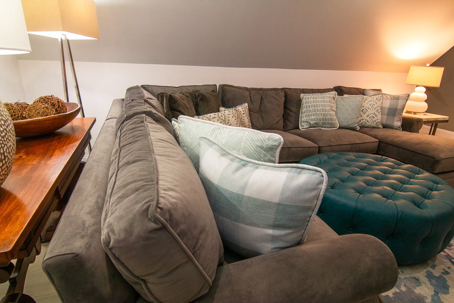 A large brown sectional with blue and white gingham pillows